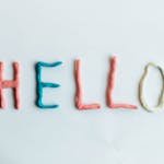 Creative hello greeting spelled out with colorful clay on a white background.