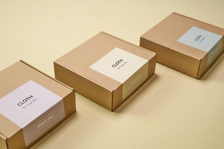 Three minimalist cardboard packages labeled 'CLOTH' on a yellow background.